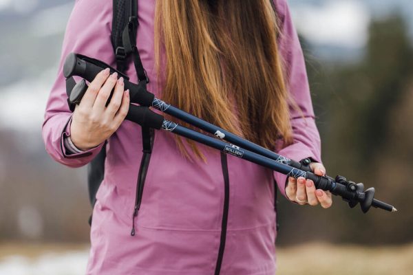 nainen, joka pitää Alpine Explorer sauvoja